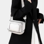 Sac Banane Bandoulière Femme Cuir Chic Poche Avant de couleur blanche porté sur l'épaule avec une sangle stylée