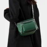 Sac Banane Bandoulière Femme Cuir Chic Poche Avant vert porté sur l'épaule avec une veste noire