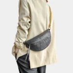 Sac Banane Femme Cuir Chaîne Dorée cuir noir style chic Sac Banane Femme Cuir Chaîne Dorée noir porté en bandoulière avec des vêtements chic