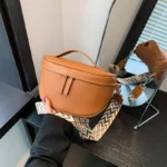 Sac Banane Femme Cuir Chic Bandoulière couleur marron orange brun avec lanière porté dans une main