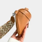 Sac Banane Femme Cuir Chic Bandoulière marron avec finition grainée et bandoulière à motif ethnique tenu dans une main