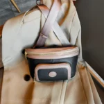 Sac Banane Femme Cuir Chic Bicolore noir et beige avec lanière élégante Sac Banane Femme Cuir Chic Bicolore noir et beige avec une lanière posé sur un vêtement beige