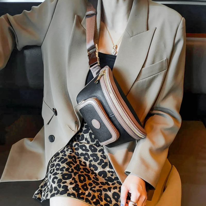 Sac Banane Femme Cuir Chic Bicolore en noir et beige porté sur l'épaule par une femme en blazer avec une jupe léopard