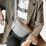 Sac Banane Femme Cuir Clouté en cuir gris avec clous et porté en bandoulière Sac Banane Femme Cuir Clouté en cuir gris porté en bandoulière avec des clous décoratifs