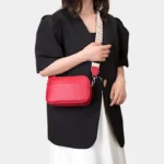 Sac Banane Femme Cuir Rectangulaire Bandoulière rouge porté sur l'épaule avec une sangle à motifs