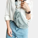 Sac Banane Femme Cuir Rock Chic en cuir bleu ciel avec poche zippée porté en bandoulière Sac Banane Femme Cuir Rock Chic bleu ciel porté en bandoulière avec une poche zippée avant