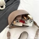 Sac Banane Femme Grand Format Simili Cuir marron avec contenu divers et lanière imprimée Sac Banane Femme Grand Format Simili Cuir marron ouvert avec divers objets à l'intérieur comme des cosmétiques et un téléphone