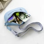 Sac Banane Femme Simili Cuir Bleu Ciel ouvert avec divers objets à l'intérieur et bandoulière en tissu