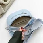 Sac Banane Femme Simili Cuir Bleu Ciel ouvert avec une main tenant la bandoulière et intérieur clair au design moderne