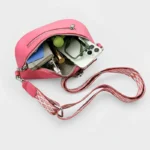 Sac Banane Femme Simili Cuir Fluo rose ouvert avec son contenu visible et une lanière large