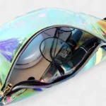 Sac Banane Transparent Holographique ouvert montrant des objets à l'intérieur comme des lunettes et des cosmétiques