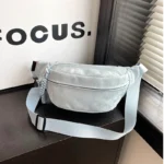 Sac Banane Velours Lisse bleu clair avec sangle d'ajustement et finition élégante Sac Banane Velours Lisse bleu clair en position latérale avec sangle d'ajustement sur fond neutre