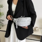 Sac Banane Velours Lisse gris avec lanière porté à la taille Sac Banane Velours Lisse gris porté à la taille par une personne en blazer noir