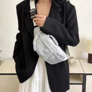 Sac Banane Velours Lisse gris porté sur l'épaule avec sangle en travers du corps dans un cadre intérieur chic