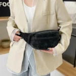 Sac Banane Velours Lisse noir élégant porté sur le côté avec style Sac Banane Velours Lisse noir porté sur le côté avec une tenue chic en blazer beige