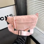 Sac Banane Velours Lisse rose avec bandoulière et texture douce Sac Banane Velours Lisse rose avec une bandoulière suspendu à la main en velours lisse