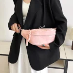 Sac Banane Velours Lisse rose en velours porté à la main style chic Sac Banane Velours Lisse de couleur rose en matière velours tenu à la main dans un style chic