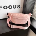 Sac Banane Velours Lisse rose en velours avec sangle ouverte sur surface en bois Sac Banane Velours Lisse de couleur rose en velours avec sangle ouverte présenté sur une surface en bois