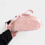 Sac Banane Velours Lisse rose en velours doux avec sangle souple Sac Banane Velours Lisse de couleur rose en velours doux présenté à la main avec une sangle souple