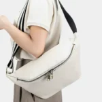 Sac Banane XL Cuir blanc avec lanière noir et blanc porté sur l'épaule par une femme
