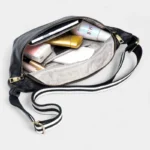 Sac Banane XL Cuir noir ouvert avec divers cosmétiques à l'intérieur