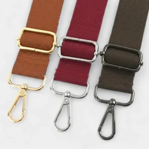 Bandoulière Simple Toile Unie Réglable en polyester marron, bordeaux et noir avec mousquetons métalliques brillants.