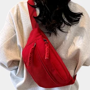 Banane velours côtelé rouge portée en bandoulière par une femme de dos au style décontracté