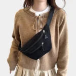 Sac banane velours côtelé noir porté en bandoulière par une femme, au style streetwear