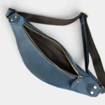 Petit sac banane cuir bleu vu de dessus, poche principale ouverte révélant des poches zippées à l’intérieur