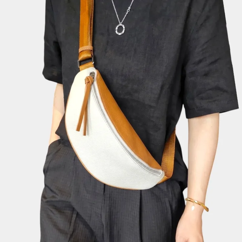 Sac banane cuir grainé bicolore blanc et camel porté en bandoulière par une femme de face