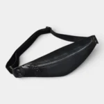 Petit sac banane cuir noir posé en diagonale, vu de dessus avec fermeture zippée chromée sur la face