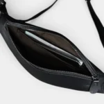 Petit sac banane cuir noir vu de dessus, poche principale ouverte contenant un smartphone
