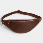 Petit sac banane cuir marron vintage posé à plat de face, avec fermeture zippée dorée