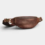 Petit sac banane cuir marron vintage posé de face, avec boucle de sangle et fermoir métal doré