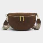 Sac banane marron en daim posé de face, avec sangle à motifs chevrons et fermeture dorée