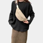 Sac banane velours côtelé beige porté en bandoulière par une femme au style minimaliste avec une sangle crème