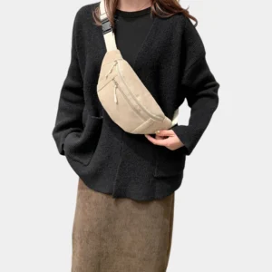 Sac banane velours côtelé beige porté en bandoulière par une femme au style minimaliste avec une sangle crème