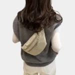 Sac banane velours côtelé beige porté dans le dos par une femme, au style streetwear