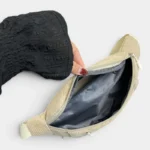 Sac banane velours côtelé beige posé vu de dessus, poche principale ouverte révélant une poche zippée intérieure