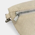 Sac banane velours côtelé beige vu de face en gros plan avec fermeture zippée en métal couleur argent