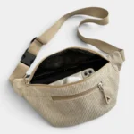 Sac banane velours côtelé beige posé vu de dessus, poche principale ouverte laissant apparaître un smartphone