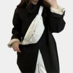 Sac banane velours côtelé blanc porté en bandoulière par une femme, au style minimaliste