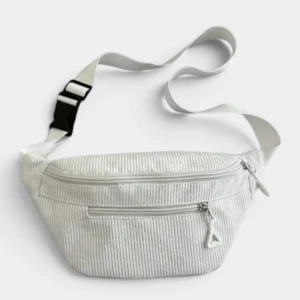 Sac banane velours côtelé blanc neige posé de face, avec sangle blanche ajustable à clip en plastique