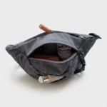 Sac banane velours côtelé gris ardoise vu de dessus face, poche principale ouverte révélant un portefeuille et une bouteille