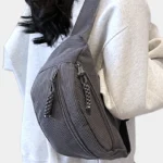 sac banane velours côtelé gris porté en bandoulière par une femme, vu de profil