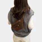 Sac banane velours côtelé marron porté en bandoulière par une femme de dos