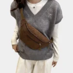 Sac banane velours côtelé marron porté en bandoulière par une femme au style streetwear, vue de face