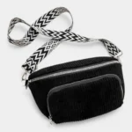 Sac banane velours côtelé noir posé de face, avec sangle graphique à motif géométrique noir et blanc