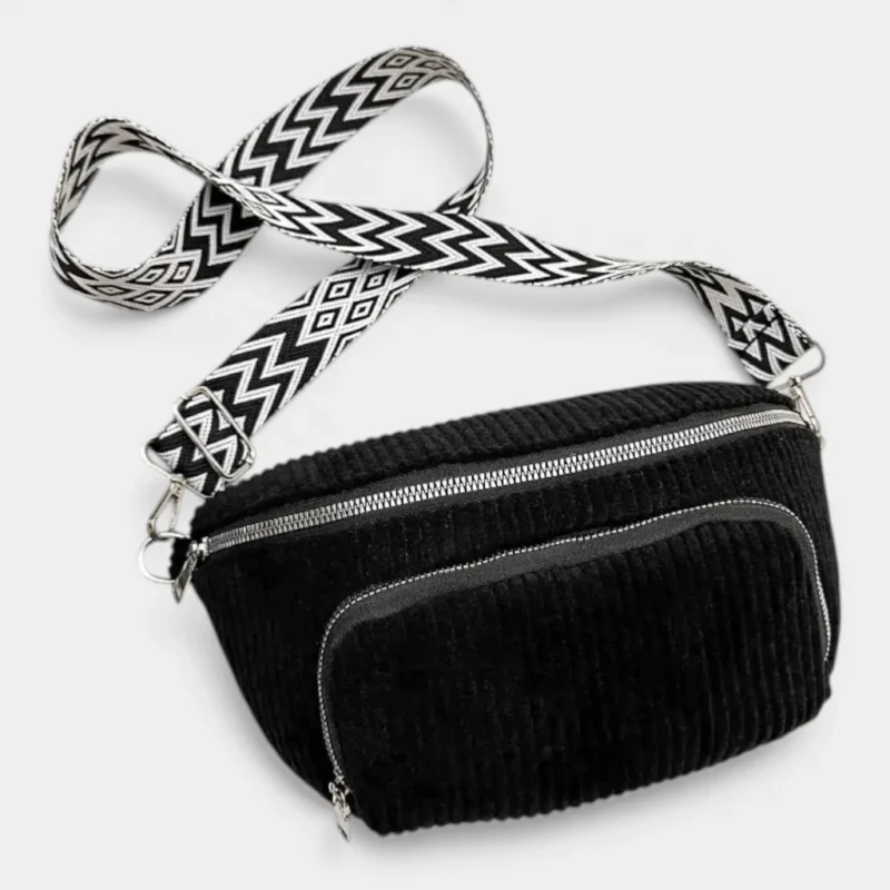 Sac banane velours côtelé noir posé de face, avec sangle graphique à motif géométrique noir et blanc