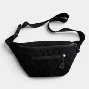 Sac banane velours côtelé noir profond posé de face, avec sangle réglable et fermetures à tirette triangle
